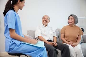 nurse or caregiver meeting and talking with about health with senior couple