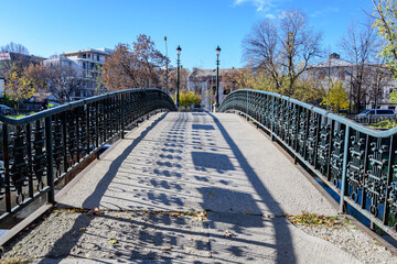 Old green metallic rusted bridge over Dambovita river in Bucharest, Romania, in a sunny autumn day