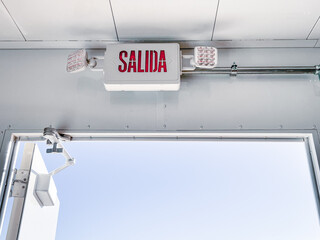 exit signs in spanish mounted over the industrial door