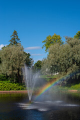 Beautiful landscape - rainbow in a fountain in the middle of the pond in the Valli park the Pärnu city centre on a sunny summer day. Parnu, Estonia.