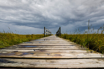 Fototapeta premium wooden bridge over the north sea in cloudy skies