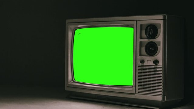 Vintage TV Green Screen Zoom In Old Television Close Up. Vintage television with green screen, for replacement, on the ground with black background. Zoom in