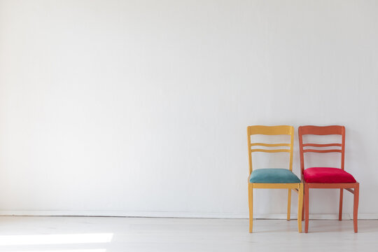 Two colorful chairs in the interior of a white room