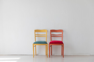 Two colorful chairs in the interior of a white room