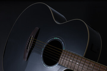Black acoustic guitar close up isolated on black background - obrazy, fototapety, plakaty