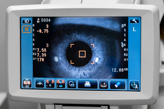Lady looking at refractometer eye testing machine in ophthalmology, tonometer screen image