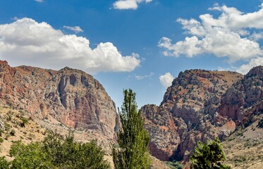 Nature landscape with cliffs, rocks, tree and clouds on sky