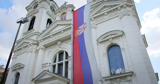 Serbian flag waves on a pole in front of Serbian Orthodox church in Sremski Karlovci