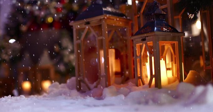 Christmas lamps with burning candles and falling snowflakes on the street