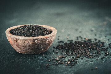 Chia seed in a rustic bowl on green background
