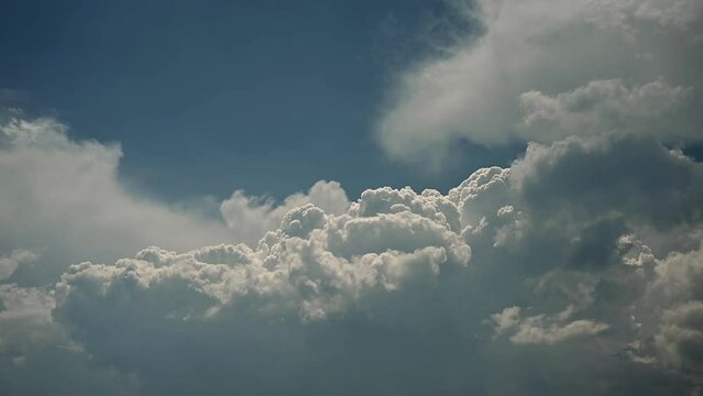  Time lapse of white to blueish grey storm clouds building in a blue sky.  The clouds are slowly developing into thunderheads.
