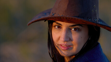 Portrait shot of a young cowgirl wearing a cowboy hat posing for the camera - travel photography