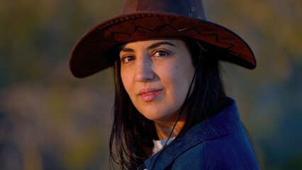 Portrait shot of a young cowgirl wearing a cowboy hat posing for the camera - travel photography