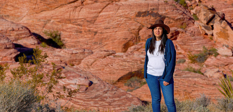 Young woman in a western style outfit exploring the amazing Red Rock Canyon in Nevada - travel photography