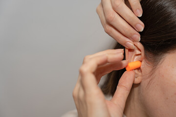 Woman Inserting Earplug for Hearing Protection