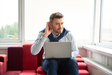 Man in casual clothes with a laptop in coworking space