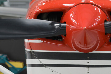 Front part of a red aircraft with a propeller. Screws, texture, surface, close-up