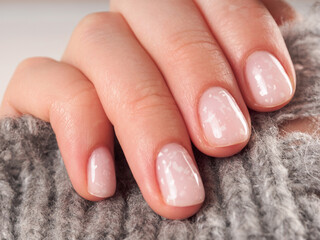Women's manicure shellac soft pink color close-up