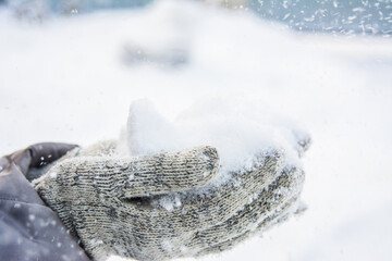 fluffy snow in the cold winter in gloved hands, swirling snow and snowfall, winter weather