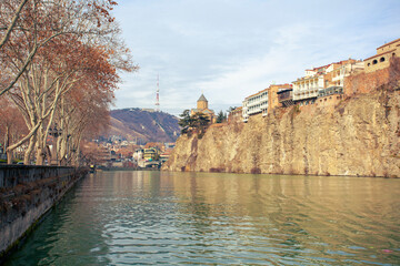 Obraz premium Metekhi church and Houses on the edge of a cliff above the river Kura