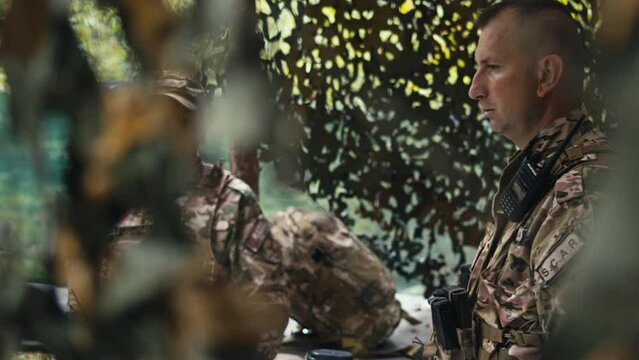 The Officer Talking to His Assitant in the Forest Base
