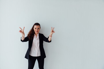Beautiful woman in business suit in office showing four fingers with hand