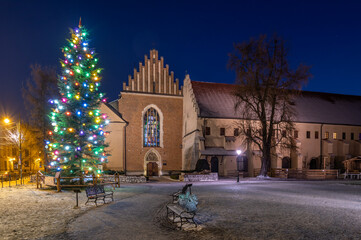 Winter in Krakow, Christmas Tree and St Francis church in the snow, night, Poland.