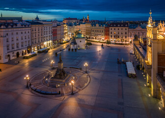 Main Square, Adam Mickiewicz monument and St Adalbert church illuminated in the night, Krakow, Poland