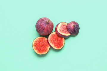 Fresh juicy cut figs on turquoise background