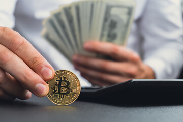 Expert trader hands showing Bitcoin coin digital gold after counting income banknotes of dollar cash on calculator. Close up of hands unrecognizable Freelancer. Earned trading charts growth 