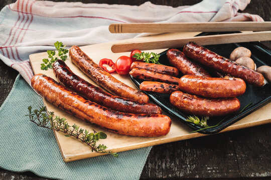 Gegrillte &ouml;sterreichische K&auml;sekrainer auf rustikalem Holzbrett