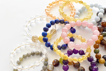 Collection of crystal gemstones bracelets on the table.