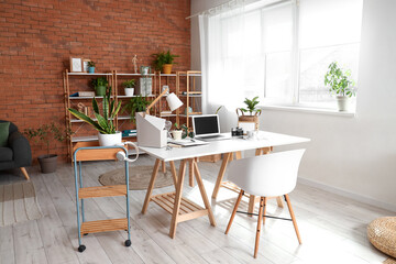 Fototapeta na wymiar Interior of home office with workplace and shelf unit