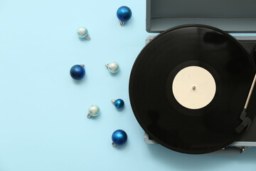 Vintage vinyl record player and Christmas balls on blue background
