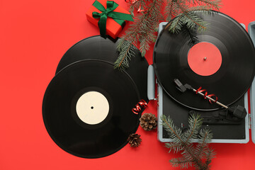 Festive Christmas music concept with vinyl record player and decorations on red background