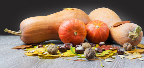 Image of pumpkin and autumn leaves on a wooden surface providing space for products or...