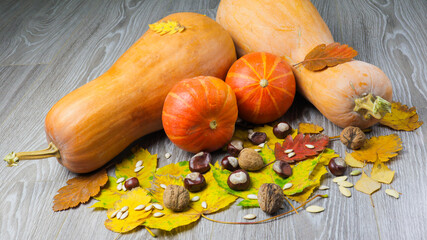 Image of pumpkin and autumn leaves on a wooden surface providing space for products or...