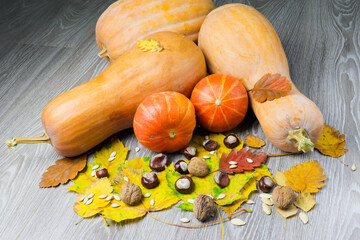 Image of pumpkin and autumn leaves on a wooden surface providing space for products or...