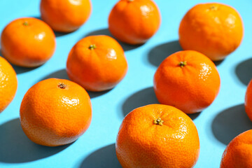 Many sweet mandarins on blue background