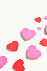 Romantic composition with red and pink paper hearts on white background. St. Valentine's Day.