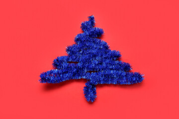 Christmas tree made of blue tinsel on red background