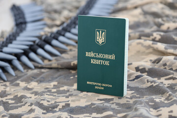 Ukrainian military ID on fabric with texture of pixeled camouflage. Cloth with camo pattern in...