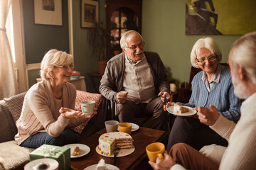 Senior people eating cake together at home