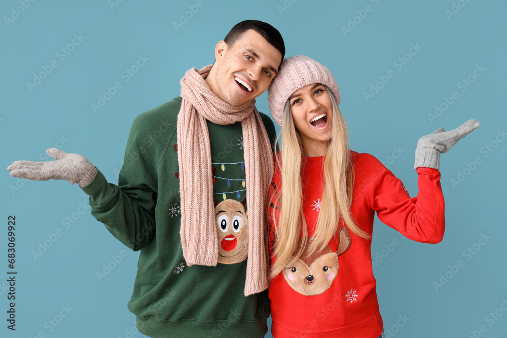 Canvas Prints young couple in christmas sweaters on blue background