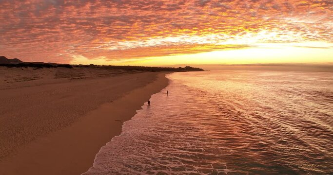 Amazing Moody Skies Aerial Flying Above Two Fisherman Casting Out to Sea At Sunset on a Mexican Beach in Cabo