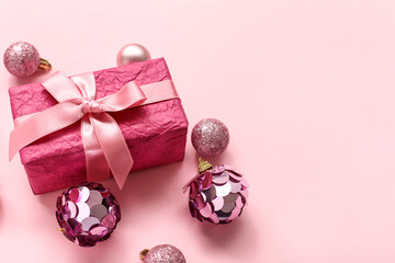 Christmas tree balls with gift on pink background