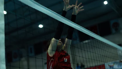 Fotobehang young woman volleyball player at match © izzetugutmen
