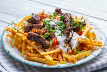 Turkish food; Cokertme Kebab - Beef meat kebab with yoghurt and french fries