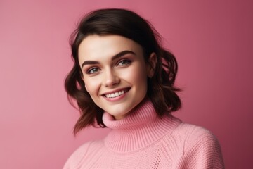 Fototapeta premium dark-haired woman smiling on a pink background in a pink sweater