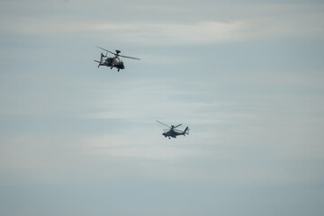two British army Boeing Apache Attack helicopter gunships AH64E (AH-64E ArmyAir606) in close proximity flight